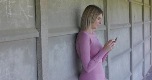 Een Jonge Vrouw Casual Kleding Staat Tegen Een Getextureerde Betonnen — Stockvideo