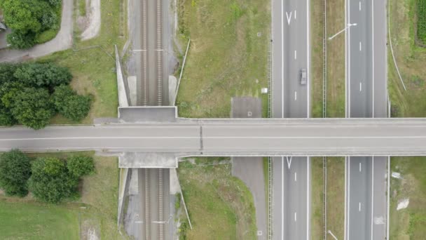 这张照片是由一架无人驾驶飞机从上方拍摄的 其特点是在铁路轨道上有一个精心设计的公路立交桥 精雕细琢的设计确保了畅通无阻的运输流动 车辆在高速公路上行驶 — 图库视频影像
