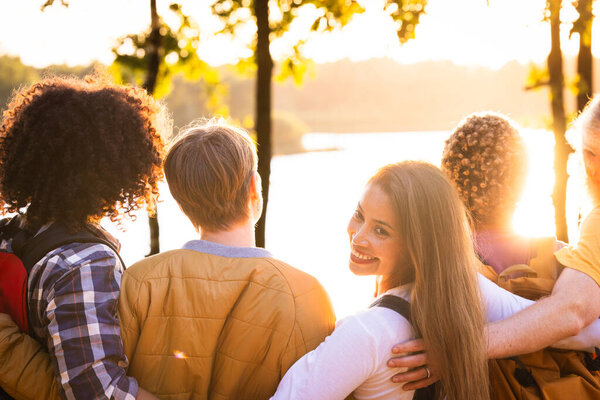 Это душераздирающее изображение запечатлевает группу друзей, наслаждающихся закатом у озера. Их спины к камере, друзья находятся в близких объятиях, символизирующих их сильную связь. Одна женщина обращает ее
