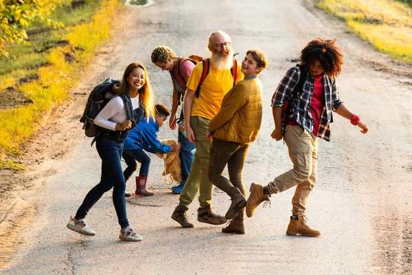 Bu canlı fotoğraf, bir kır yolunda neşeli bir anı paylaşan farklı bireylerden oluşan bir grubu yakalıyor. Kompozisyon onları neşeli bir etkileşim içinde gösteriyor. Etraflarında gülücükler ve gülücükler var.