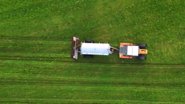 この映像は 活気に満ちた緑地を横断する方法的に肥料を散布するトラクターの最上階の視点を提供し 作物のきちんと傾いた列との厳しいコントラストを生み出します このビジュアル — ストック動画