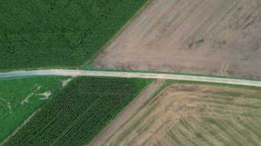 Bu insansız hava aracı görüntülerinde, tarım arazilerinin yamalı doğasını gösteren verimli yeşil ekili tarlalar ve bitişik nadasa arasında çarpıcı bir zıtlık var. Bölünen çizgiler...