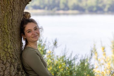 Genç, esmer, bin yıllık bir kadın doğasında huzuru bulur. Bir orman gölünün kenarında oturuyor, bir ağaca yaslanıyor, yemyeşil bir yaz gününde yemyeşil ortamın huzurunun tadını çıkarıyor.