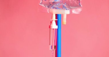 Bu stok görüntüler acil tıbbi bakımlarda kullanılan ve bir ambulansın titreşen ışıkları tarafından aydınlatılan serumu yakalıyor. Değişen renkler aciliyeti simgeliyor.