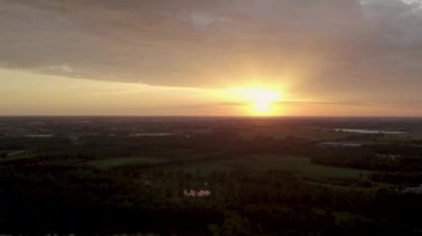 Bu nefes kesen dron görüntüsü günbatımının ihtişamını yakalıyor. Uzak gölleri olan geniş bir orman manzarasının üzerine inerken sönen ışığı yansıtıyor. Ufuk alevler içinde kaldı.