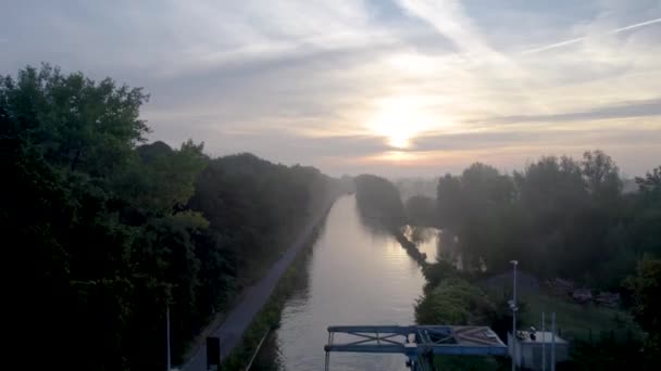 这段录像捕捉到了清澈的黎明在一条运河上破晓的美景 周围环绕着茂盛的风景 空中射击从一座桥和几辆车的近景转向更广阔的视角 — 图库视频影像