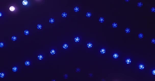 这段录像展示了一系列耀眼的彩灯点缀在游乐场的墙壁上 在暮色中形成了一个充满活力的蓝色挂毯 闪烁着光芒的灯泡闪烁着舞动着 投出一个 — 图库视频影像