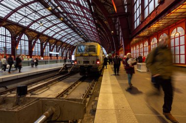 Antwerp, Belçika, 25 Ocak 2024, Antwerp Merkez İstasyonu 'nda canlı bir günlük ulaşım anı yakalanıyor. 1902 numaralı tren hazır beklerken, banliyö aciliyeti her birini bulanıklaştırıyor.