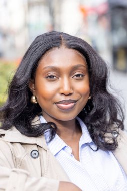 Bu çarpıcı yakın plan, kameraya bakarken gözleri sevinçten kıpır kıpır parlayan siyah bir kadını canlandırıyor. Arkasındaki kentsel ortam bulanıklaşıyor. Parlak cildine dikkat çekiyor.