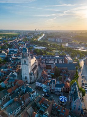Batan güneş, Belçika 'nın Halle kentinin üzerine, kalıcı güzelliğin özünü yansıtan bu hava görüntüsünde hafif bir parıltı saçar. Görüntünün merkezinde muhteşem