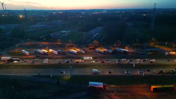 这段录像记录了一个高速公路交叉口深夜的嗡嗡声 卡车在那里停了很多活动 背景是一片广阔的风景 黄昏的微光 — 图库视频影像