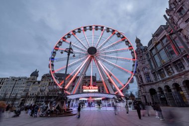 Antwerp, Belçika, 25 Ocak 2024 gün batımında, The View, dönme dolap, Antwerps 'in hareketli şehir manzarasında ışıl ışıl bir odak noktası haline gelir. Parlak ışıkları, oyunculuğa ve modern kontrast katar.