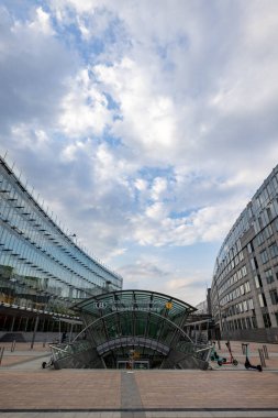 BRÜKSEL, BELGIUM, 23 Haziran 2023: Brüksel-Lüksemburg İstasyonu girişi modern cam binalarla çevrili görkemli bir gökyüzü altında, ulaşım ve mimarinin bir karışımını vurguluyor. Dramatik Gökyüzü