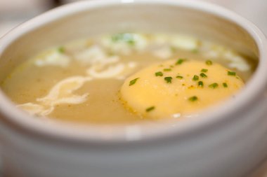 Bu resim bir kase kremalı patates çorbası sunuyor. Eriyen tereyağı ve bir tutam taze soğanla noktalanmış zengin dokusu. Rahatlatıcı bir yemek için mükemmel. Çorba sıcaklığı vaat ediyor.