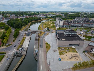Bu çekici hava fotoğrafı Belçika 'nın Halle kentinin dolambaçlı bir kanal boyunca yayıldığı panoramik bir görüntüsünü sunuyor. Kompozisyon, şehirlerin uyumunu güzel bir şekilde gösteriyor.