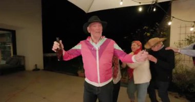 Bu canlı video açık hava partisinde eğlenen bir grup heyecanlı son sınıf misafiri gösteriyor. Neşeli bir ambiyansla, ritmik bir şekilde müziğe yönelirler, konga dansı, kadeh kaldırma ve...