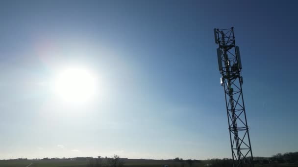 这段视频展示了电信塔或手机桅杆的高耸轮廓 其复杂的结构在明亮的晨光的映衬下闪烁着 蔚蓝的天空营造了平静的背景 — 图库视频影像