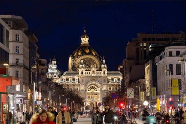 Antwerp, Belçika, 25 Ocak 2024 akşam çökerken Antwerp sokakları sakinlerinin enerjisiyle canlanıyor. Bu görüntü, insanlar geceleri meşgul olurken hareketli bir caddeyi yakalar.