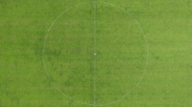 Bu yüksek açılı drone görüntüsü, canlı yeşil çimleri ve belirgin beyaz sınır çizgileriyle bir futbol sahasının tertemiz durumunu gösteriyor. Hava perspektifi geometriği vurgular