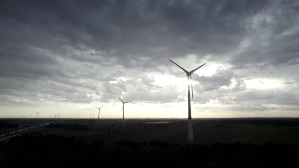 Footage Captures Striking Silhouette Wind Turbines Standing Tall Brooding Sky — стоковое видео