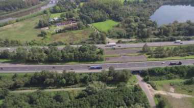 Mechelen 'in yukarısından çekilen bu drone görüntülerinde Brüksel ve Antwerp' i birbirine bağlayan hareketli bir manzara boyunca uzanan yoğun E19 karayolu görülüyor. Hava görüntüsü trafiğin akışını vurgular