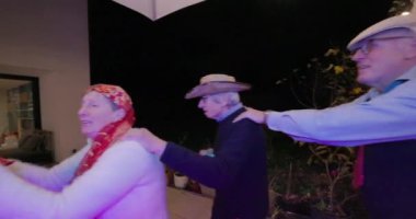 Neşeli insanların dans ettiği, neşeli ışıklar ve dekorasyonlarla eğlendiği canlı bir parti sahnesi.