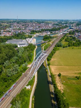Halle, Vlaams brabant, Belçika, 06 09 2023, bir kanaldan geçen demiryolu köprüsünün havadan görünüşü, yemyeşil ve kentsel manzarayla çevrili..