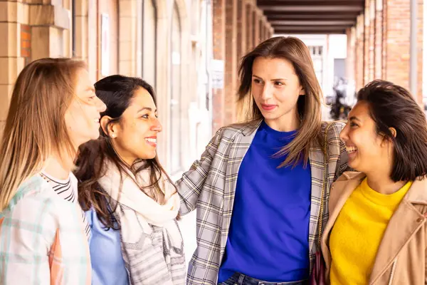 stock image A group of four young women are outdoors, enjoying each others company, laughing, and engaging in lively conversation