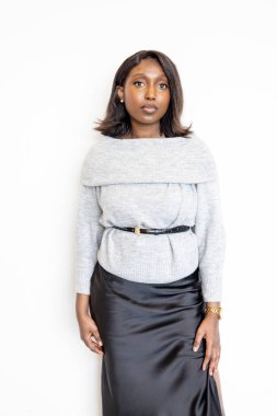 Kendine güvenen bir kadın klasik siyah bir etek ve şık gri bir bluz giyer. Modern ve zarif bir tarzı vardır.