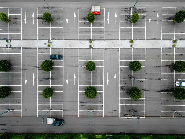 stock image A drone captures a parking lot with cars, trees, and clear markings, displaying organized urban infrastructure