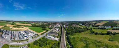 Lembeek, Halle, Vlaams Brabant, Belçika, 30 Haziran 2024, çarpıcı bir hava manzarası yemyeşil ve kentsel alanlarda akan demiryollarının güzelliğini yansıtıyor.,