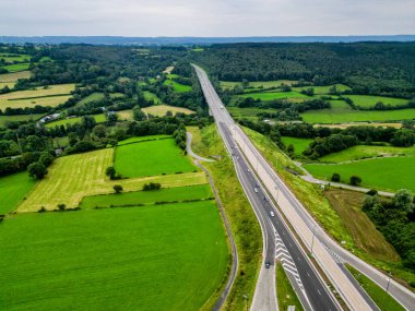 E42, A27 otoyolu Liege Trier, Stavelot, Liege, Belçika, 30 Haziran 2024 'te yemyeşil tarlalar ve görkemli yuvarlanan tepeler boyunca uzanan kırsal bir otoyolu görüntüler.