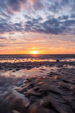 Su havuzlarına yansıyan turuncu ve mor renkli gelgit düzlüklerinde nefes kesici bir günbatımı sahnesinin tadını çıkarın.