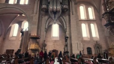 Trier, Rijnland-Palts, Almanya, 23 Mart 2024, tarihi bir katedralde yapılan törene katılan bir sürü insan güzel mimariyi gösteriyor.