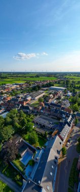 Arendonk, Antwerp, Belçika, 6 Ağustos 2024, göz kamaştırıcı hava perspektifi canlı yeşil tarlalarla çevrili büyüleyici küçük bir köy sergiliyor.