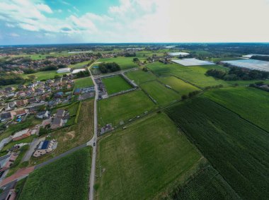 Rijkevorsel, Antwerp, Belçika, 1 Eylül 2024, geniş bir hava görüntüsü güzel yeşil alanlar ve parlak bir gökyüzünün altındaki resimli bir banliyö alanı gösteriyor.