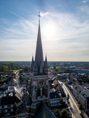 Arendonk, Antwerp, Belçika, 6 Ağustos 2024, Saint Job Kilisesi çarpıcı bir hava fotoğrafı güzel ve huzurlu bir manzaranın ortasında tarihi bir kilise kulesini çekiyor.