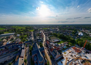Arendonk, Antwerp, Belçika, 6 Ağustos 2024, berrak mavi gökyüzünün altında canlı ve canlı bir kasaba manzarası görüntüsü.