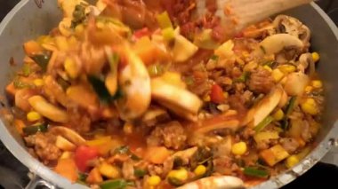 Sıcak tavada rengarenk bir pirinç, sebze ve baharatlı sos karışımı. Sağlıklı öğle ve akşam yemekleri için ideal.