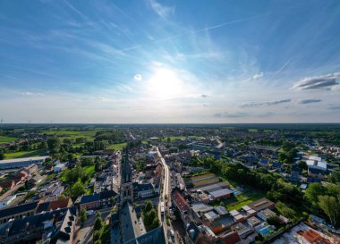 Arendonk, Antwerp, Belçika, 6 Ağustos 2024, kesinlikle göz kamaştırıcı bir hava manzarası açık mavi gökyüzünün altında yemyeşil tarlalarla çevrili canlı bir kasaba yakalıyor.