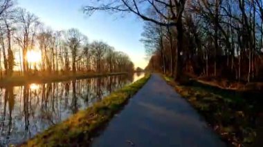Gün batımında huzurlu bir kanal manzarası doğanın canlı renklerini yansıtıyor.