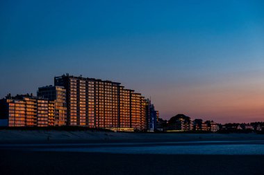 Nieuwpoort, Belçika, 5 Ekim 2024, modern şehir siluetinin nefes kesici ve çarpıcı görüntüsü alacakaranlık saatlerinde güzelliği gözler önüne seriyor.