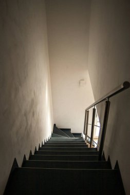 Çağdaş bir merdiven doğal ışık akışıyla zarifçe aydınlatılıyor, sakin, minimalist bir atmosferi teşvik ediyor.