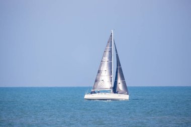 Nieuwpoort, Belçika, 5 Ekim 2024, berrak mavi sularda süzülen sakin bir yelkenli sahnesi macera ve sükunet için mükemmel..