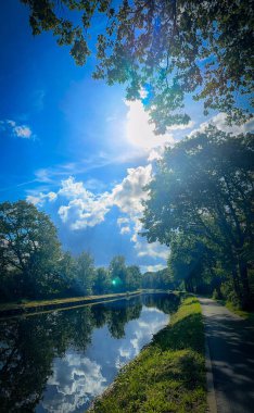 Huzurlu ve huzurlu bir nehir manzarası güzel yansımaları ve yemyeşil yeşillikleri sergiliyor.