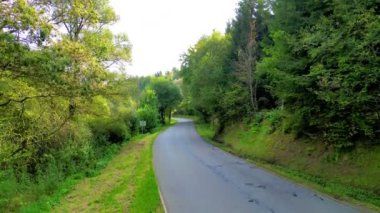 Sakin, dolambaçlı bir yol canlı ağaçlar ve çimenlik alanlarla doludur, doğa severler ve açık hava hayranları için mükemmeldir.