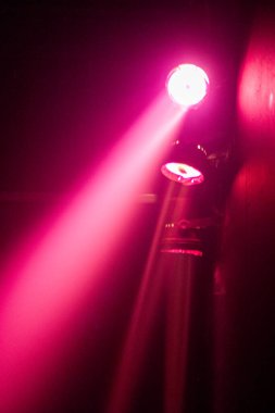 Sahne görselleri ve performansı için ideal, karanlık bir ortamda parlak pembe spot ışıkları.