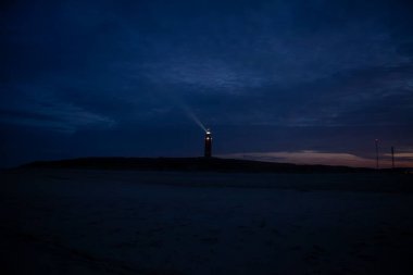 De Cocksdorp, Texel, Hollanda, 27 Ekim 2024, sakin bir deniz feneri alacakaranlık gökyüzüne karşı gururla duruyor,