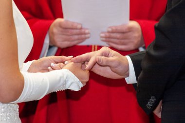 Sevgi dolu bir çift, bir papazın yönettiği son derece içten bir tören sırasında alyanslarını mutlulukla değiş tokuş ederler.