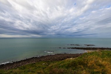 A stunning coastal landscape with a dramatic sky and serene sea, offering a breathtaking view of natures beauty clipart